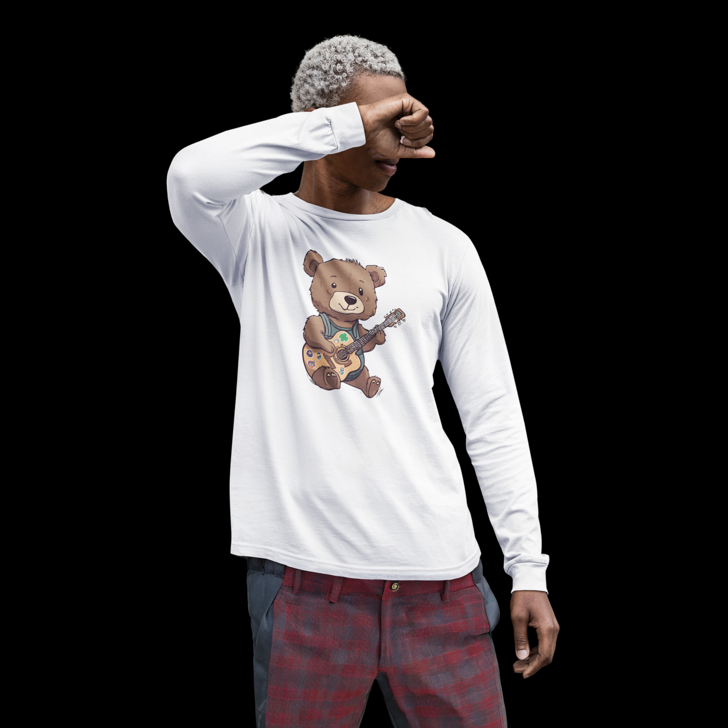 White long sleeve cotton t-shirt with a graphic of a bear strumming a guitar decorated with little stickers, including a shamrock